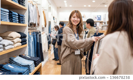 A clothing store clerk serving customers with a smile A clothing store clerk serving customers with a smile 136678238