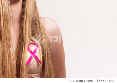Woman chest in bra, pink cancer ribbon 136678429