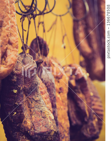 Smoked sausages meat hanging in smokehouse 136678508