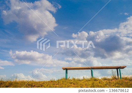 Bench against blue sky with light clouds. Bottom view Bench against blue sky with light clouds. Bottom view 136678612