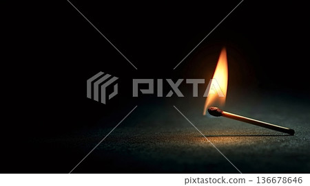 Burning match illuminating dark surface representing hope and energy Burning match illuminating dark surface representing hope and energy 136678646