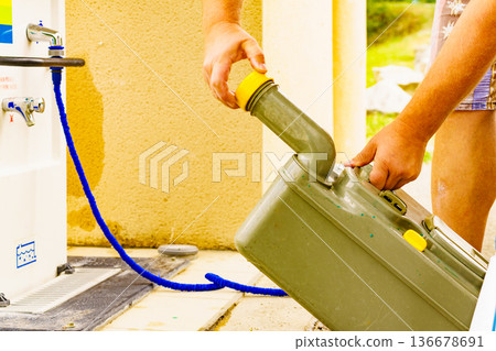 Man emptying caravan tank toilet cassette in dump station. Man emptying caravan tank toilet cassette in dump station. 136678691