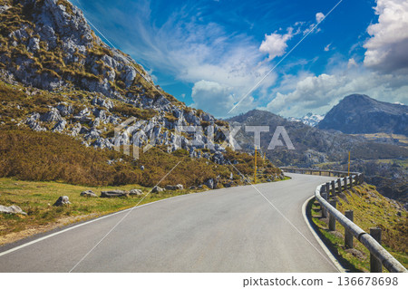 View of beautiful mountain landscape through the windscreen on a sunny day. Driving a car on mountain winding road in National park Picos de Europa. Cantabria, Spain, Europe View of beautiful mountain landscape through the windscreen on a sunny day. Driving a car on mountain winding road in National park Picos de Europa. Cantabria, Spain, Europe 136678698