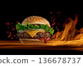 Delicious burger on a black background with fire. 136678737