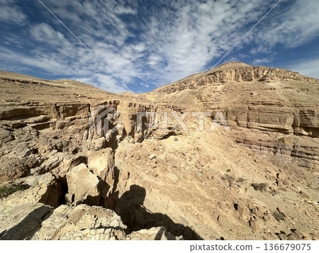 Eilat Mountains desert landscape with layered sedimentary cliffs and dramatic sky Eilat Mountains desert landscape with layered sedimentary cliffs and dramatic sky 136679075