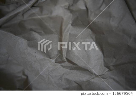 Crumpled brown kraft paper texture with rough fold 136679564