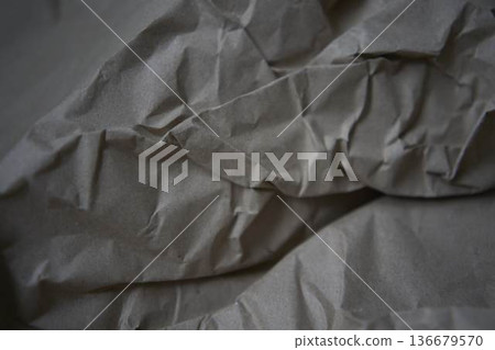 Crumpled brown kraft paper texture with rough fold 136679570