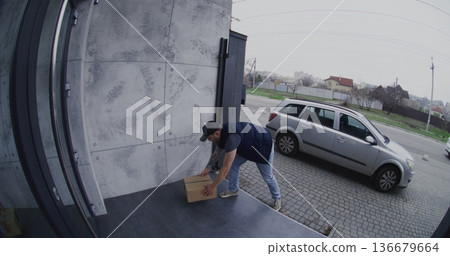Courier in Silver Car Places Parcel on Porch and Takes Smartphone Photo For Confirmation Courier in Silver Car Places Parcel on Porch and Takes Smartphone Photo For Confirmation 136679664