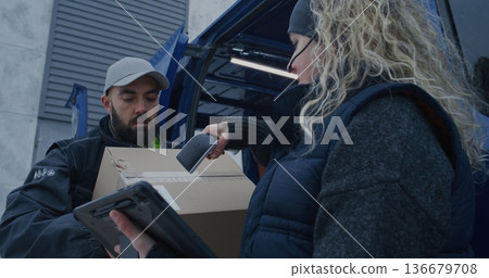 Man Moves Boxes While Woman Uses Scanner and Tablet Check Shipments Man Moves Boxes While Woman Uses Scanner and Tablet Check Shipments 136679708