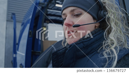 Woman Wearing Headset Scans Packages With Scanner and Tablet Woman Wearing Headset Scans Packages With Scanner and Tablet 136679727