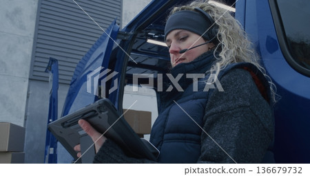 Man Moves Boxes While Woman Uses Scanner and Tablet Check Shipments Man Moves Boxes While Woman Uses Scanner and Tablet Check Shipments 136679732