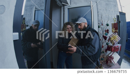 Male Courier in Uniform Delivers Cardboard Box Female Customer Male Courier in Uniform Delivers Cardboard Box Female Customer 136679735