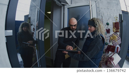 Professional Female Courier Hands Over Large Document Envelope to Man at Front Door Professional Female Courier Hands Over Large Document Envelope to Man at Front Door 136679742