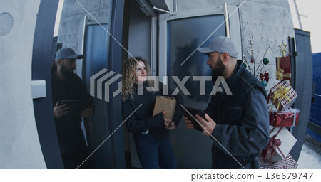 Male Courier in Uniform Delivers Cardboard Box Female Customer Male Courier in Uniform Delivers Cardboard Box Female Customer 136679747
