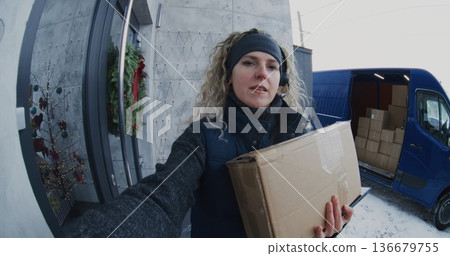 Female Courier With Headset Carries Parcel Front Door Female Courier With Headset Carries Parcel Front Door 136679755