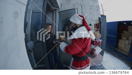 Santa Claus Delivers Package to Woman at Doorstep Santa Claus Delivers Package to Woman at Doorstep 136679764
