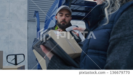 In Cold Snowy Weather, Delivery Crew Loads Parcels Into Van 136679770