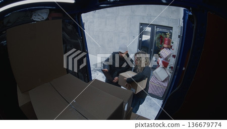 Professional Courier Retrieves Cardboard Boxes From Blue Delivery Van Professional Courier Retrieves Cardboard Boxes From Blue Delivery Van 136679774