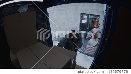 Professional Courier Retrieves Cardboard Boxes From Blue Delivery Van Professional Courier Retrieves Cardboard Boxes From Blue Delivery Van 136679776