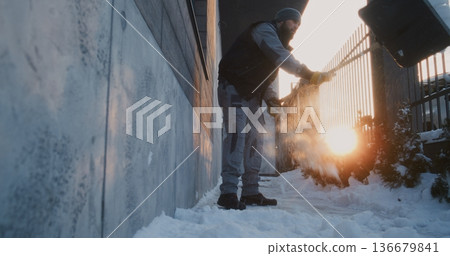 Focused Man Uses Plastic Shovel For Manual Property Upkeep Near Wall and Metal Fence Focused Man Uses Plastic Shovel For Manual Property Upkeep Near Wall and Metal Fence 136679841