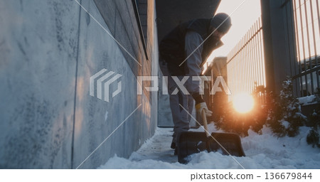 Focused Man Uses Plastic Shovel For Manual Property Upkeep Near Wall and Metal Fence Focused Man Uses Plastic Shovel For Manual Property Upkeep Near Wall and Metal Fence 136679844