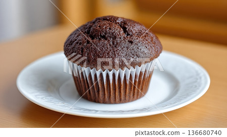 Delicious Chocolate Muffin Placed on a White Plate Ready to Be Enjoyed in a Cozy Setting Delicious Chocolate Muffin Placed on a White Plate Ready to Be Enjoyed in a Cozy Setting 136680740