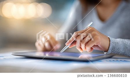 Hands Align Savings Plan Pages and Use Digital Tablet for Planning at a Table in an Office Setting 136680810