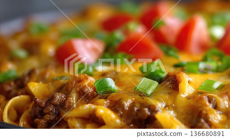 Closeup View of Cheesy Pasta With Ground Beef and Fresh Tomatoes in a Warm Setting 136680891