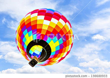 Colorful hot air balloon flying over blue sky with white clouds Colorful hot air balloon flying over blue sky with white clouds 136680933