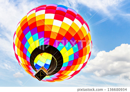 Colorful hot air balloon flying over blue sky with white clouds Colorful hot air balloon flying over blue sky with white clouds 136680934