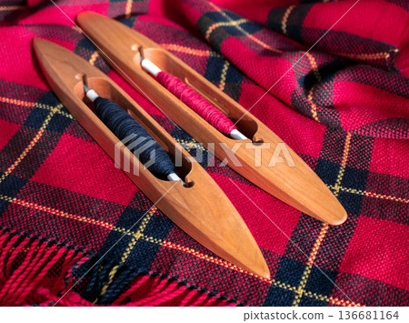 Handwoven fabric showcasing traditional craftsmanship and weaving tools. This vibrant textile is a testament to the artistry of handmade weaving 136681164