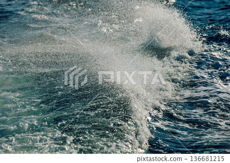 A wave of the Barents Sea breaks against a strong wind in sunny weather 136681215
