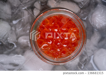 fresh red caviar served in small jar around ice cubes. macro shot. Protein delicacy healthy food. flat lay fresh red caviar served in small jar around ice cubes. macro shot. Protein delicacy healthy food. flat lay 136681315