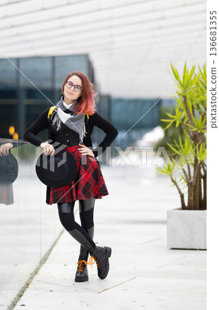 Trendy young woman with pink hair posing in urban setting Trendy young woman with pink hair posing in urban setting 136681355