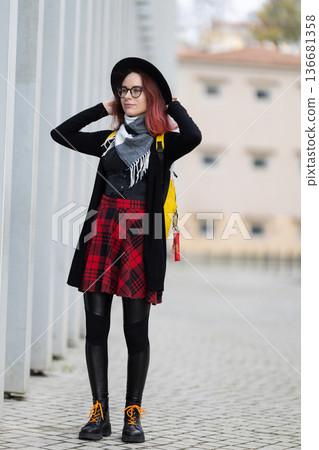 Young woman styling black hat and plaid skirt Young woman styling black hat and plaid skirt 136681358