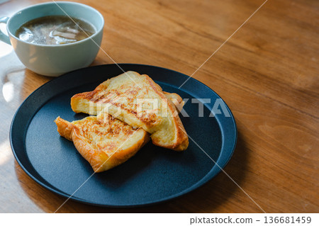 法式吐司和湯盛在黑色盤子裡,一份簡單的早餐畫面。 法式吐司和湯盛在黑色盤子裡,一份簡單的早餐畫面。 136681459