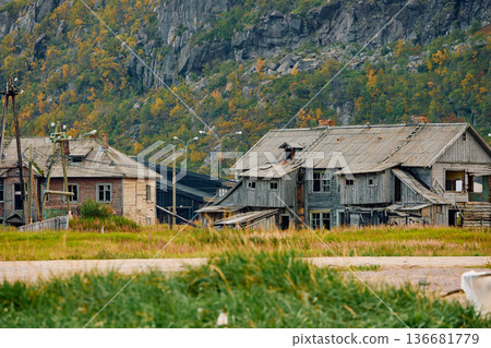 Weathered wooden houses in Teriberka at dusk, Russia, Kola Peninsula, evoke a bygone era, standing as silent witnesses to the passage of time. Teriberka's historical architecture concept Weathered wooden houses in Teriberka at dusk, Russia, Kola Peninsula, evoke a bygone era, standing as silent witnesses to the passage of time. Teriberka's historical architecture concept 136681779