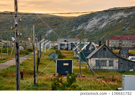 Weathered wooden houses in Teriberka at dusk, Russia, Kola Peninsula, evoke a bygone era, standing as silent witnesses to the passage of time. Teriberka's historical architecture concept Weathered wooden houses in Teriberka at dusk, Russia, Kola Peninsula, evoke a bygone era, standing as silent witnesses to the passage of time. Teriberka's historical architecture concept 136681782