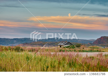 Weathered wooden houses in Teriberka at dusk, Russia, Kola Peninsula, evoke a bygone era, standing as silent witnesses to the passage of time. Teriberka's historical architecture concept Weathered wooden houses in Teriberka at dusk, Russia, Kola Peninsula, evoke a bygone era, standing as silent witnesses to the passage of time. Teriberka's historical architecture concept 136681786