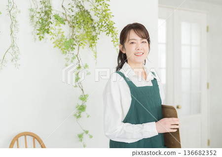 有圍裙的微笑的一名婦女 136682352