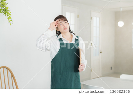 A woman with a smile wearing an apron A woman with a smile wearing an apron 136682366