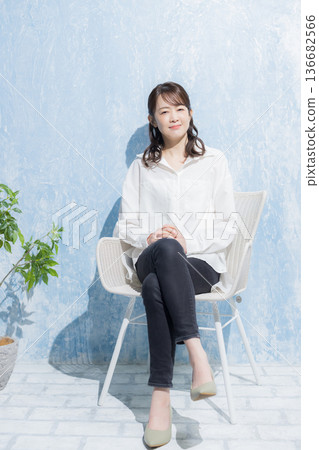 Woman sitting on a garden chair 136682566