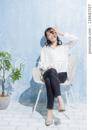 Woman sitting on a garden chair 136682567
