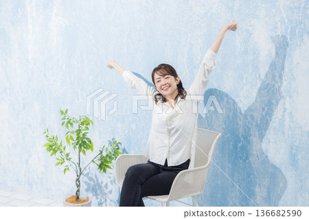 Woman sitting on a garden chair 136682590
