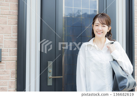 A woman in front of the entrance door going out 136682619
