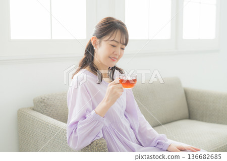 Woman drinking tea in the living room 136682685