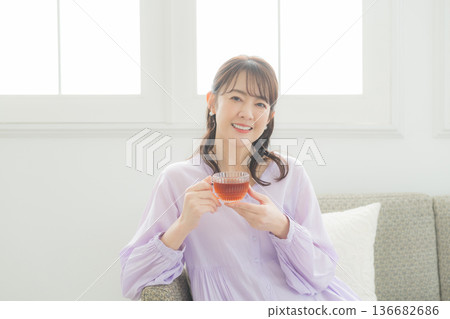 女人在客廳裡喝茶 136682686