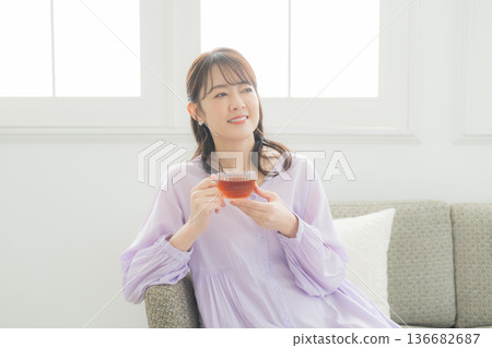 女人在客廳裡喝茶 女人在客廳裡喝茶 136682687