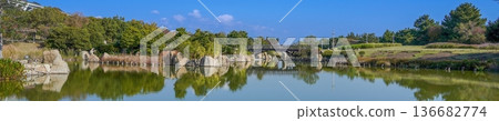 美麗的日式庭園全景,平靜的池塘倒映著水面波光粼粼,一座傳統的木橋橫跨其上。 美麗的日式庭園全景,平靜的池塘倒映著水面波光粼粼,一座傳統的木橋橫跨其上。 136682774
