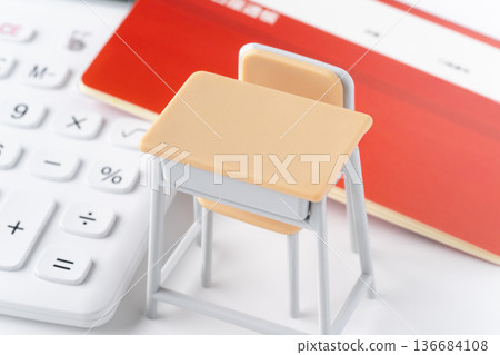 A calculator, bankbook, and a miniature school desk and chair A calculator, bankbook, and a miniature school desk and chair 136684108